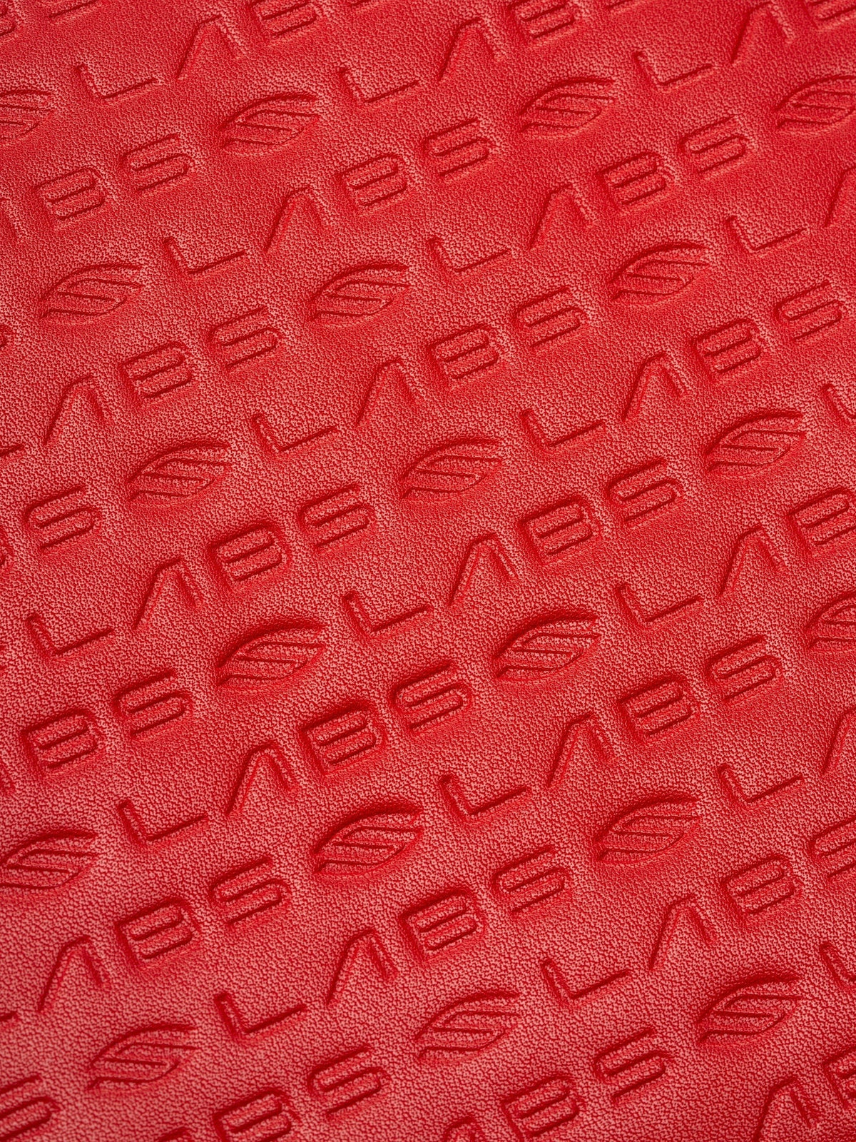 Close-up of the red textured InfiniGrit carbon fiber surface on a Pickleshop Selkirk Labs Project Boomstick paddle.